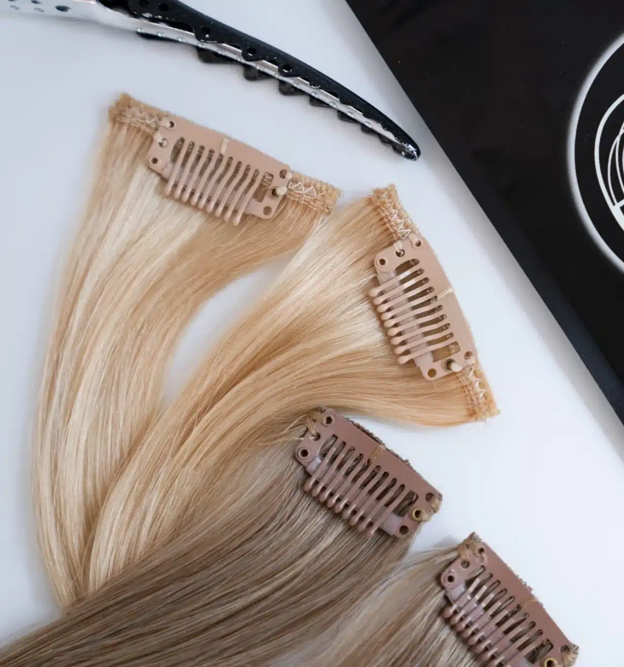 Stylist placing a clip in hair extension weft for a natural blend
