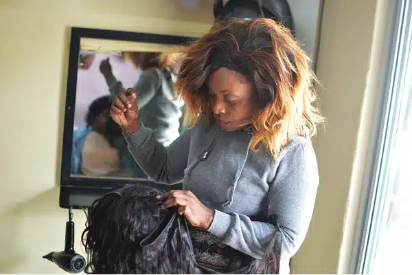 Stylist placing a clip in weft below short natural layers
