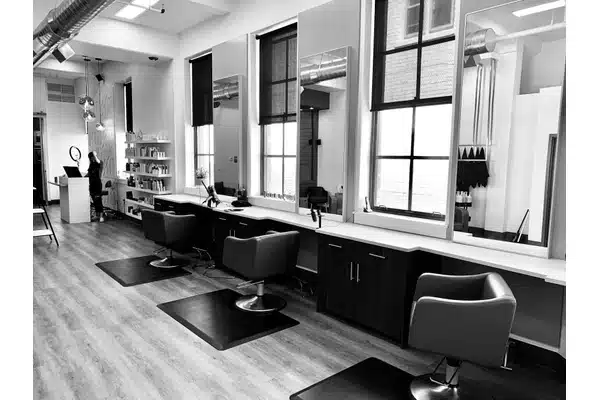 Salon stylist checking tape tab placement before a wash service
