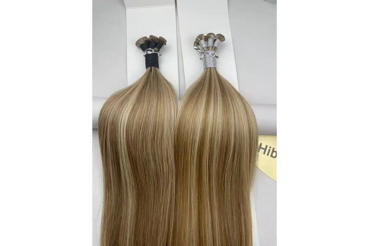 Light blonde low profile hair weft samples arranged on a clean product surface.