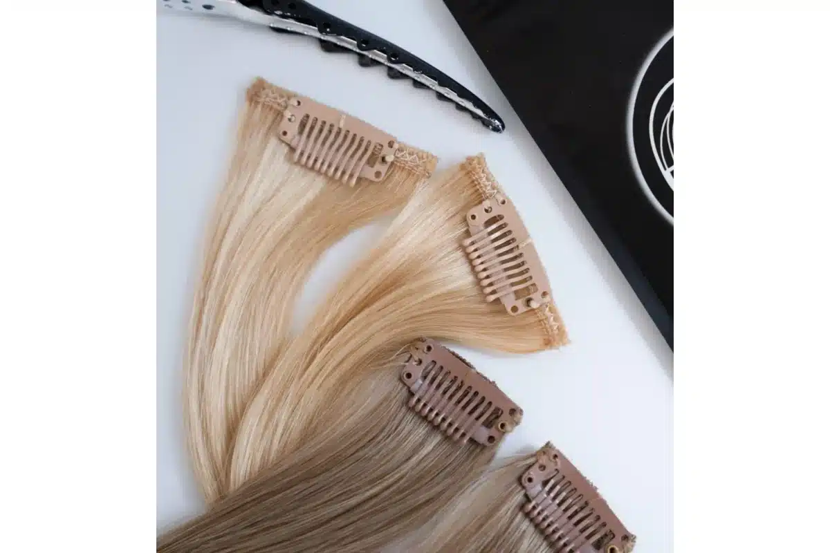 Blonde clip in extension pieces arranged with seams and pressure clips visible.