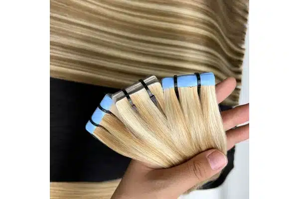 Blonde tape in hair tabs shown close up for adhesive inspection