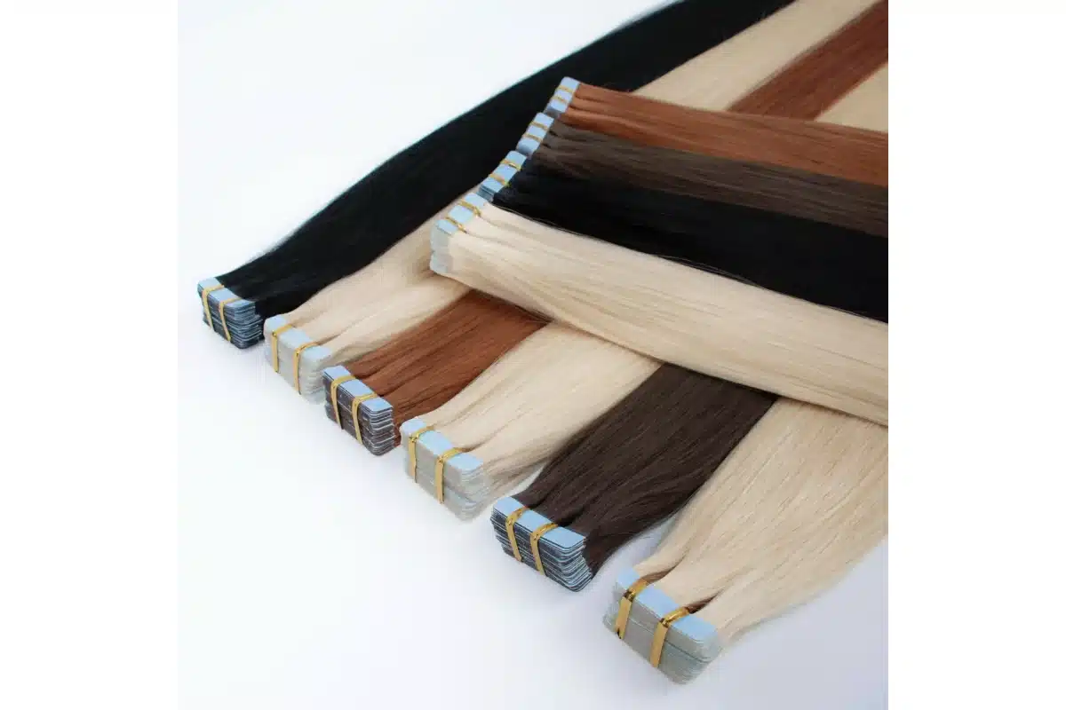 Black, brown, auburn, and blonde tape in hair panels arranged for color comparison.