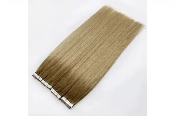 Rooted blonde tape in extensions arranged flat from their dark attachment area to lighter ends.